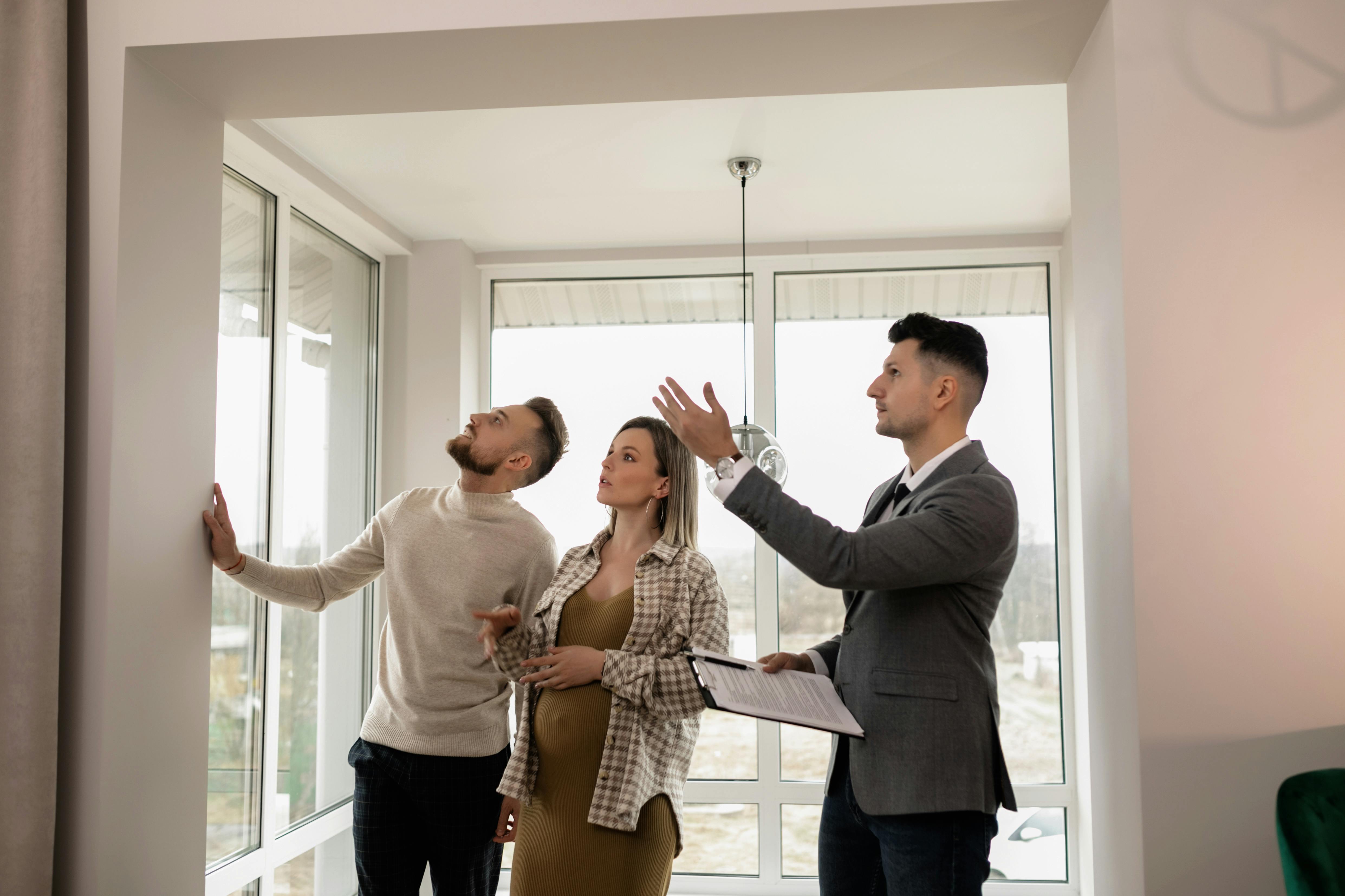 man in suit showing a couple through a house